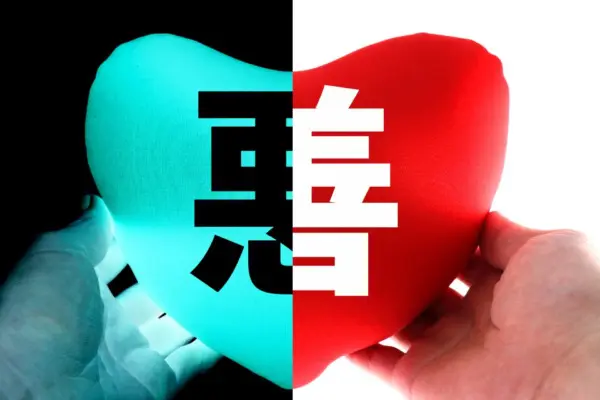 人捧著一顆心，左邊寫著「惡」、右邊寫著「善」